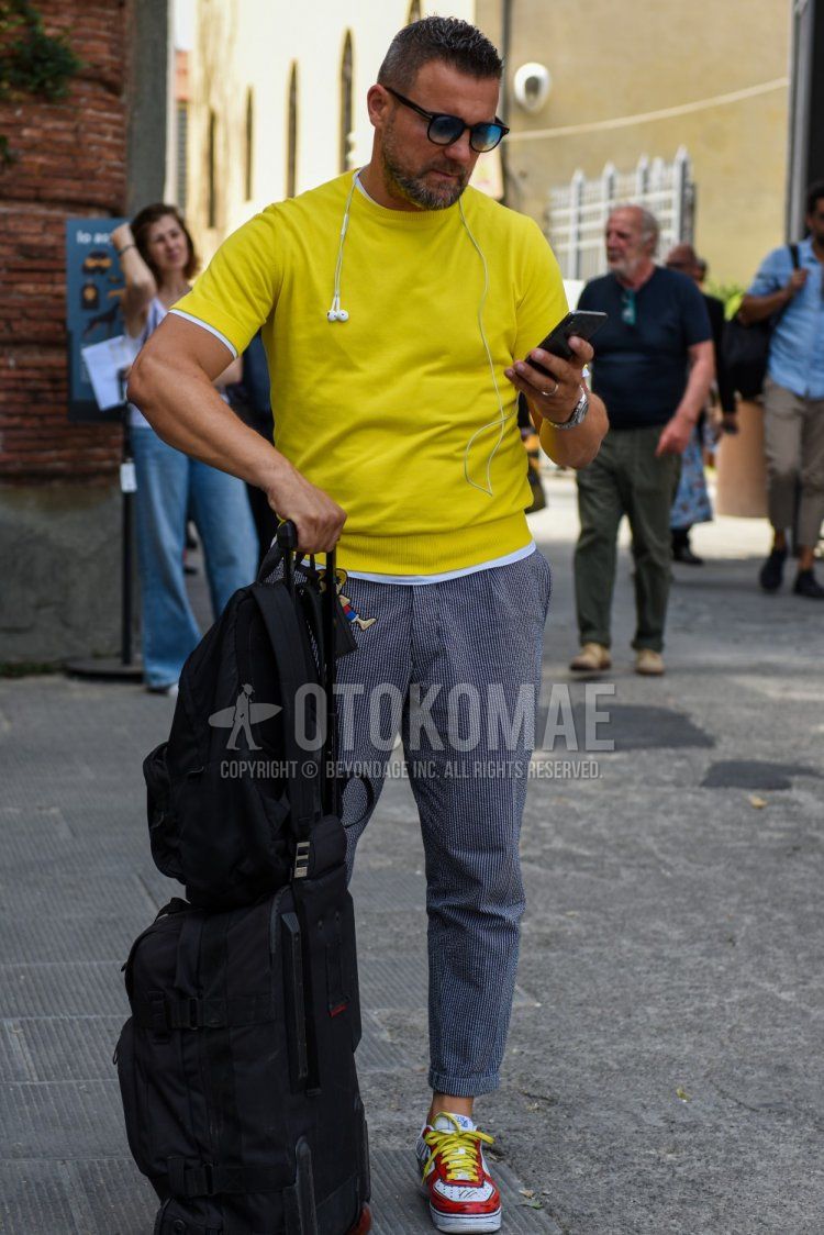 Men's spring/summer coordinate and outfit with Tom Ford plain black sunglasses, knit plain yellow t-shirt, gray striped slacks, and red/white low-cut sneakers.