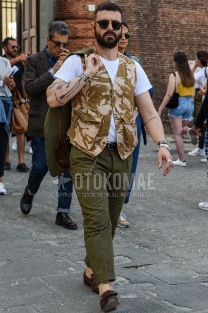 Summer men's coordinate and outfit with plain black sunglasses, plain white t-shirt, beige brown top/inner gilet, plain black leather belt, plain olive green cotton pants, brown loafer leather shoes.