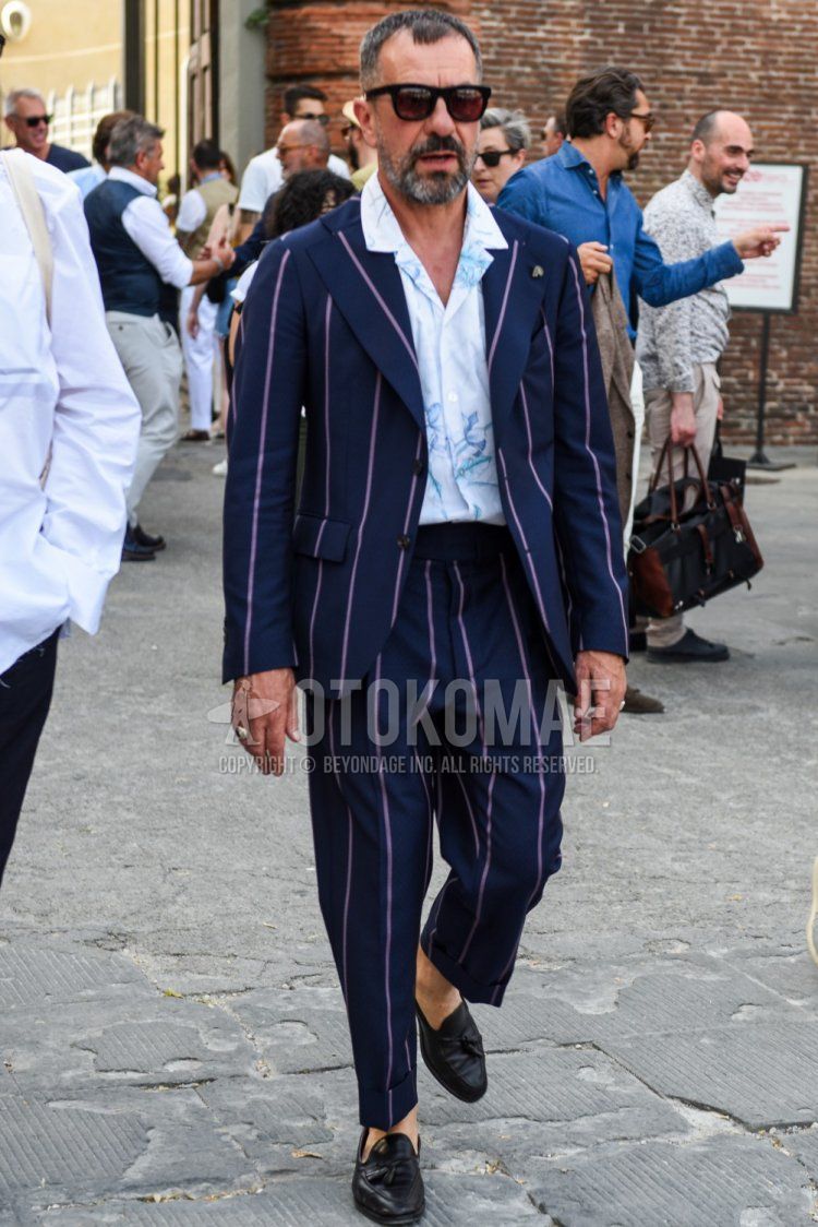 Men's spring/summer coordinate and outfit with plain black Wellington sunglasses, open collar white top/inner shirt, black tassel loafer leather shoes, and dark gray striped suit.