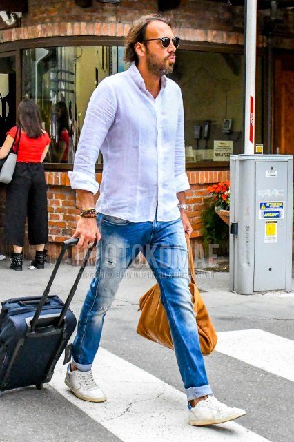 Men's spring/summer coordinate and outfit with solid color sunglasses, solid color white shirt, solid color blue denim/jeans, white low-cut sneakers, and solid color yellow Boston bag.