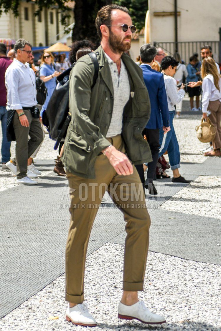 Men's spring, summer, and fall coordinate and outfit with plain sunglasses, plain olive green tailored jacket, plain gray polo shirt, plain beige chinos, and white straight tip leather shoes.