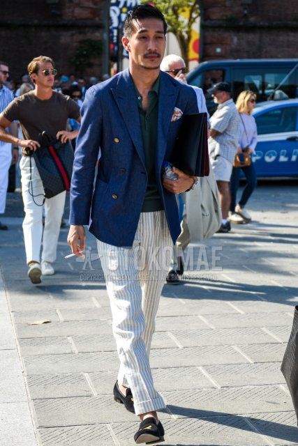 Men's spring/summer/autumn coordinate and outfit with plain navy tailored jacket, plain green polo shirt, white striped slacks, white striped ankle pants, suede black loafer leather shoes, and plain black clutch/second bag/drawstring bag.