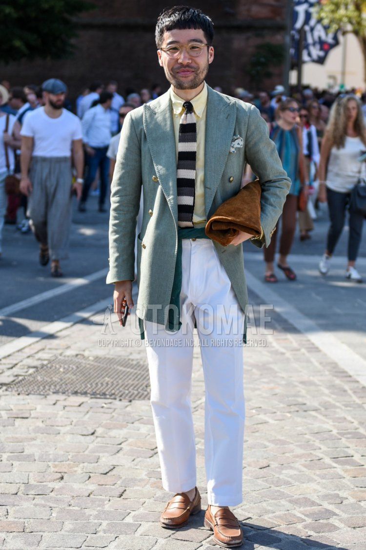 Men's spring/autumn coordinate and outfit with plain gold glasses, plain green tailored jacket, plain yellow shirt, plain white cotton pants, brown coin loafer leather shoes, plain brown clutch/second bag/drawstring, and multi-colored striped knit tie.