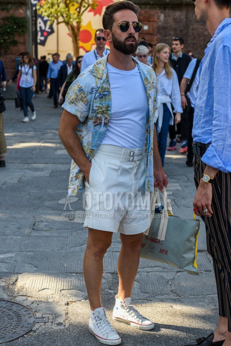 Summer men's coordinate and outfit with gold/black plain sunglasses, plain white t-shirt, multi-colored botanical shirt, plain white beltless pants, and white high-cut Converse sneakers.