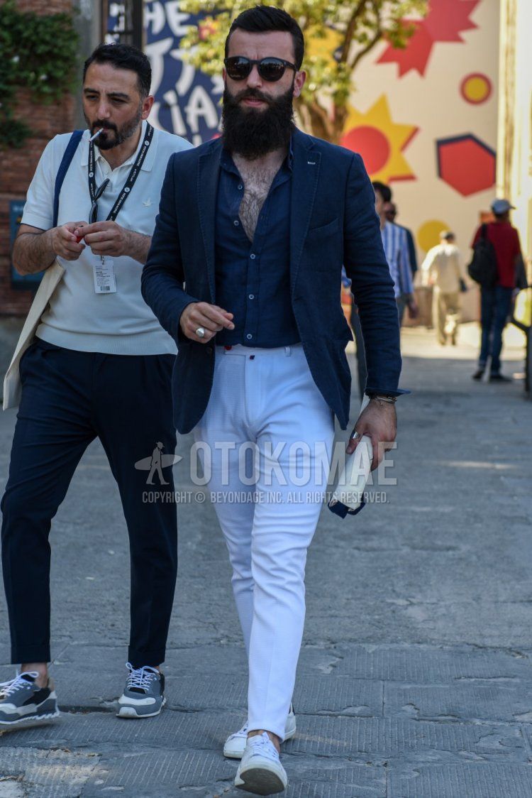 Men's spring, summer, and fall coordinate and outfit with plain black sunglasses, plain navy tailored jacket, plain navy denim/chambray shirt, plain white beltless pants, and white low-cut sneakers.