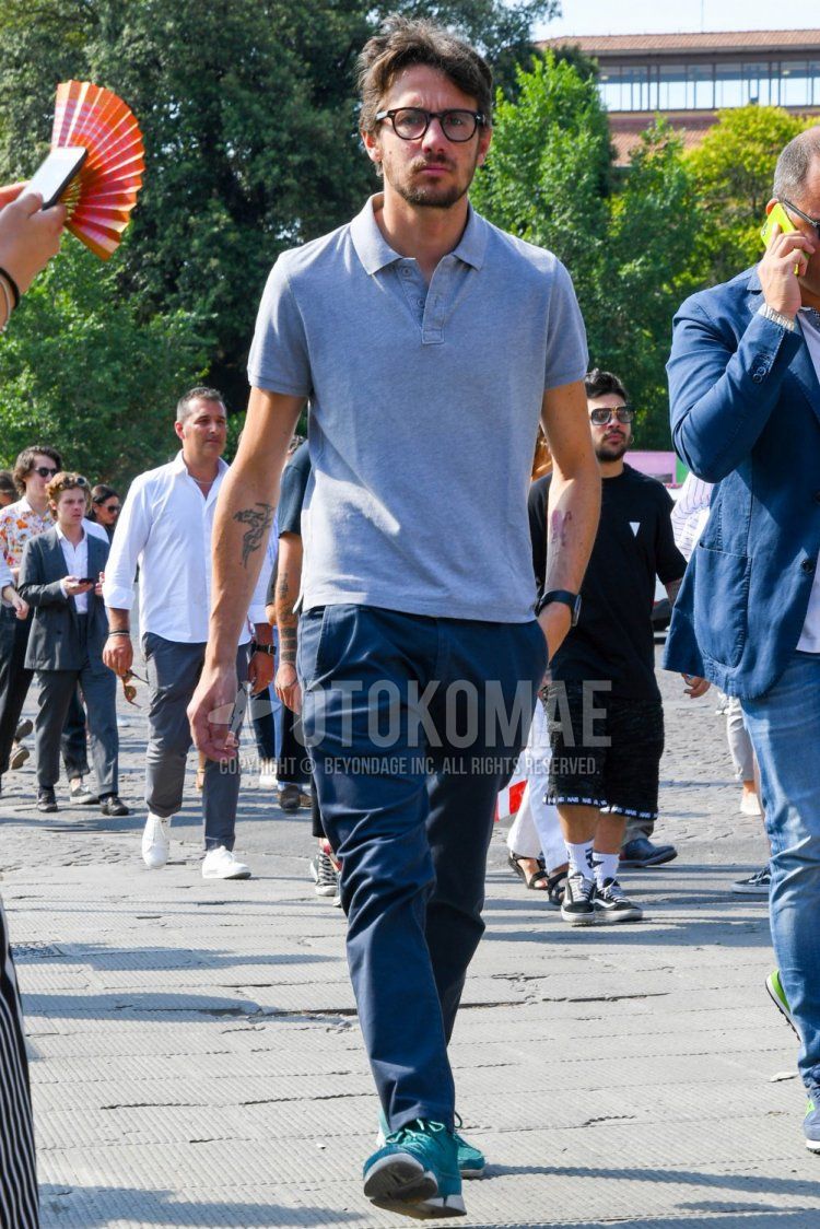Men's summer coordinate and outfit with plain glasses, plain gray polo shirt, plain navy chinos, and green low-cut sneakers.