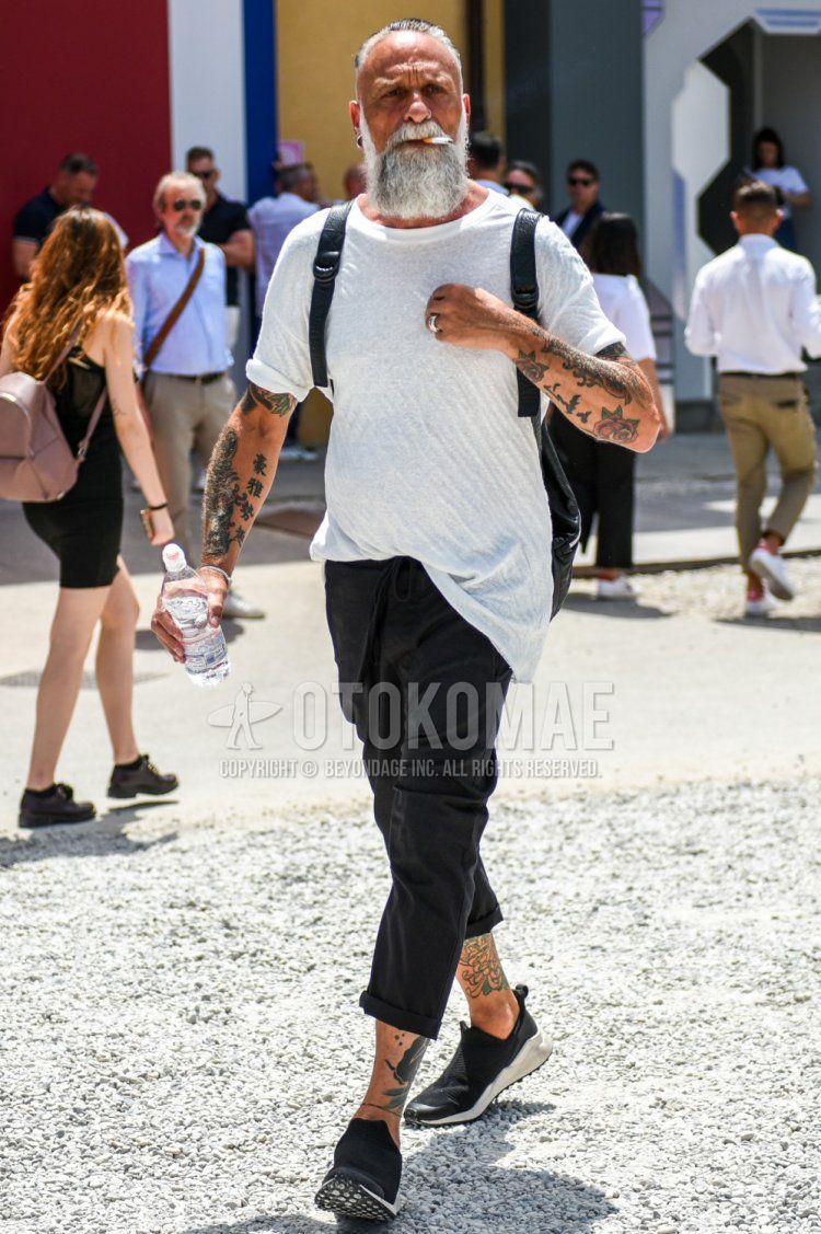 Men's summer coordinate and outfit with plain white T-shirt, plain black easy pants, and black low-cut sneakers.