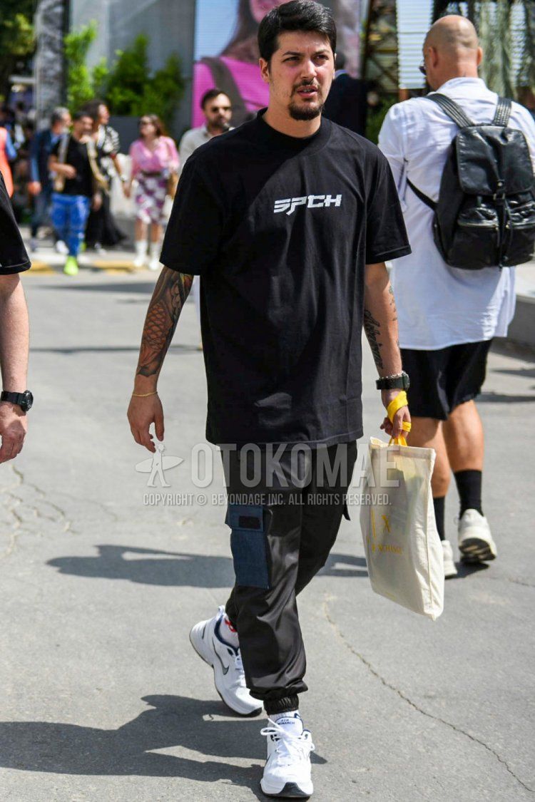 Summer men's coordinate and outfit with black one-pointed t-shirt, plain black jogger pants/ribbed pants, plain black cargo pants, plain white socks, and white low-cut Nike sneakers.