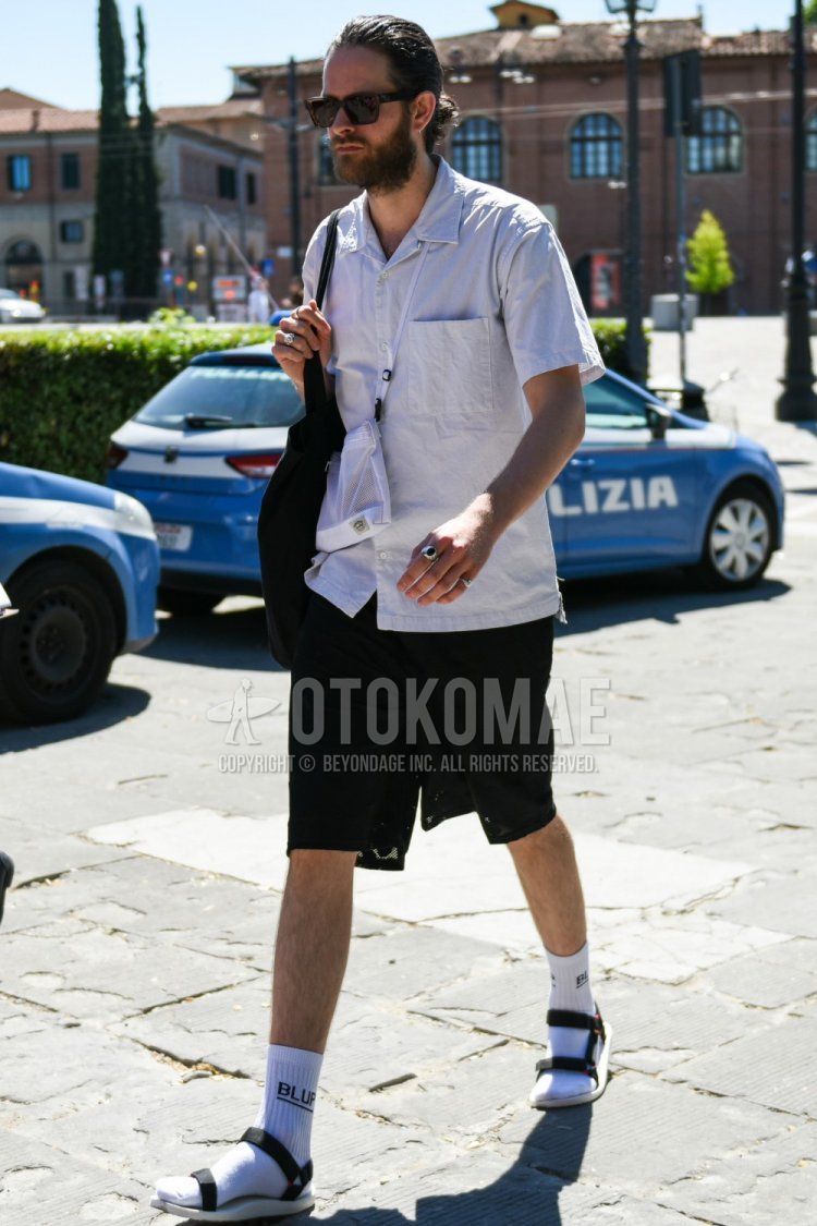 Summer men's coordinate and outfit with Wellington plain brown sunglasses, short sleeve open collar plain white shirt, white one-pointed socks, black/white sport sandals, and plain white sacoche.