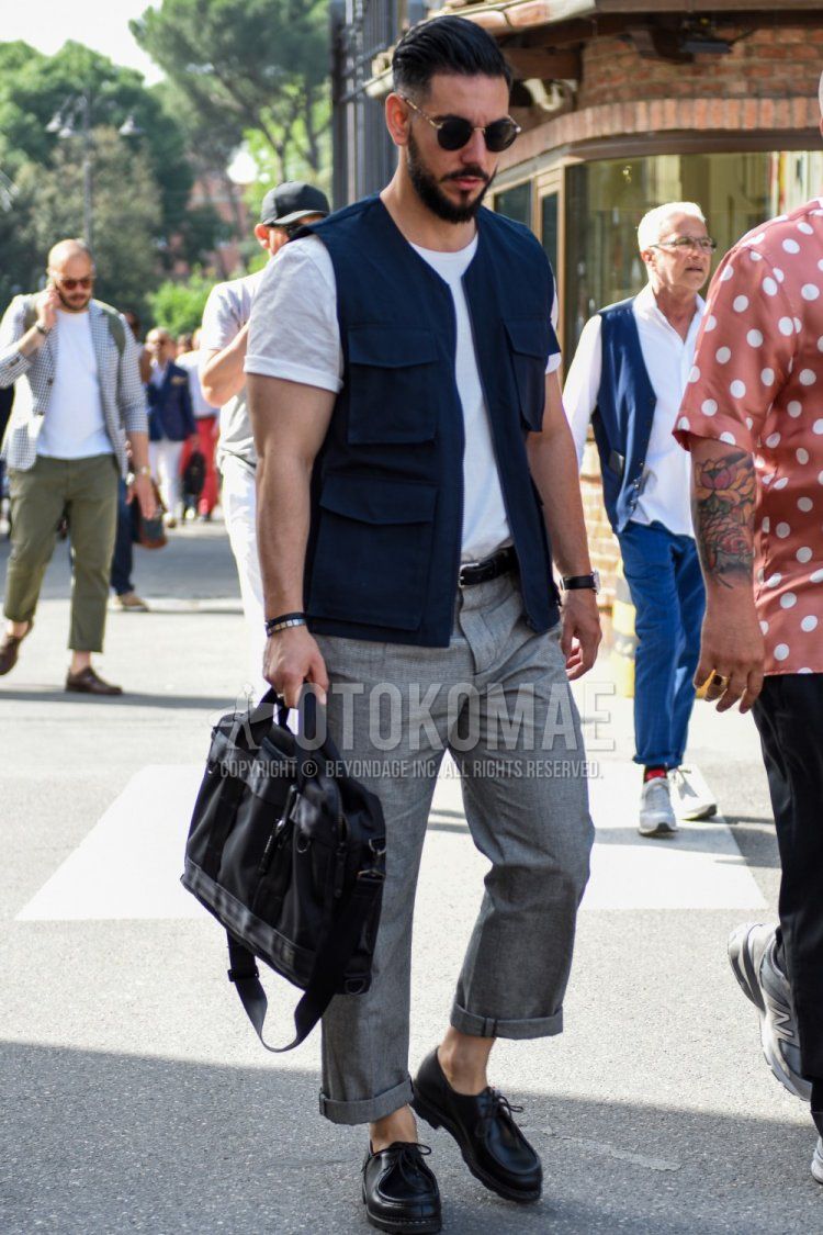 A summer men's outfit/coordination with plain black sunglasses, plain navy gilet, plain white t-shirt, plain black leather belt, plain gray slacks, black Tyrolean leather shoes, and plain black briefcase/handbag.