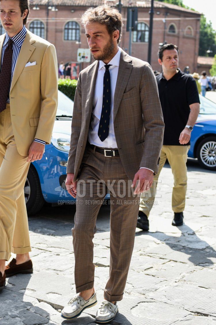 Men's spring, summer, and fall coordination and outfit with plain white shirt, plain black leather belt, white moccasins/deck shoes leather shoes, and black necktie tie.