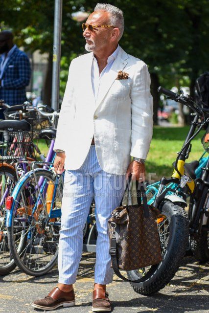 Men's spring/summer/fall outfit with yellow/brown tortoiseshell sunglasses, plain white tailored jacket, plain white shirt, light blue/white striped ankle pants, brown monk shoes leather shoes, Louis Vuitton brown plain tote bag.