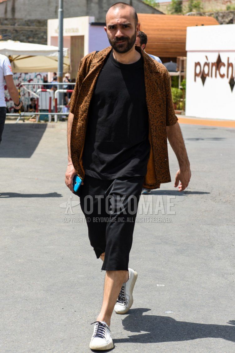 Men's spring/summer coordinate and outfit with yellow top/inner shirt, plain black t-shirt, plain black shorts, and white low-cut sneakers.