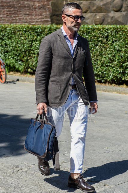 Men's spring/summer/fall outfit with solid black sunglasses, solid dark gray/brown tailored jacket, solid light blue shirt, solid brown leather belt, solid white cotton pants, brown brogue shoes leather shoes, solid blue clutch/second bag/drawstring ...and a clutch bag/second bag/drawstring.