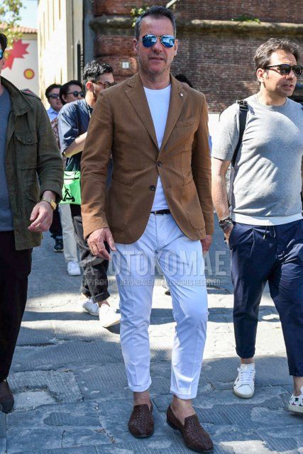 Men's spring, summer, and fall coordinate and outfit with teardrop plain blue sunglasses, plain brown tailored jacket, plain white t-shirt, plain white cotton pants, and brown loafer leather shoes.