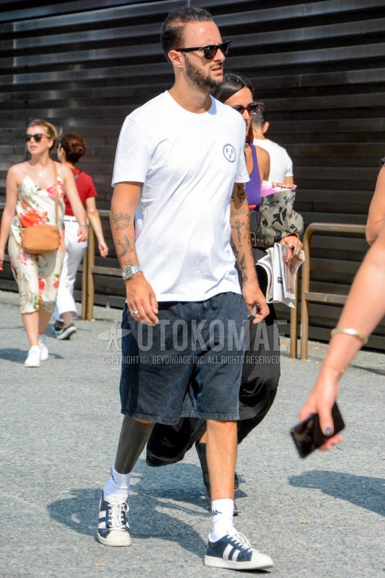 A summer men's coordinate and outfit with plain black sunglasses, white one-pointed t-shirt, plain black shorts, plain black denim/jeans, plain white socks from Kappa, and black low-cut sneakers.