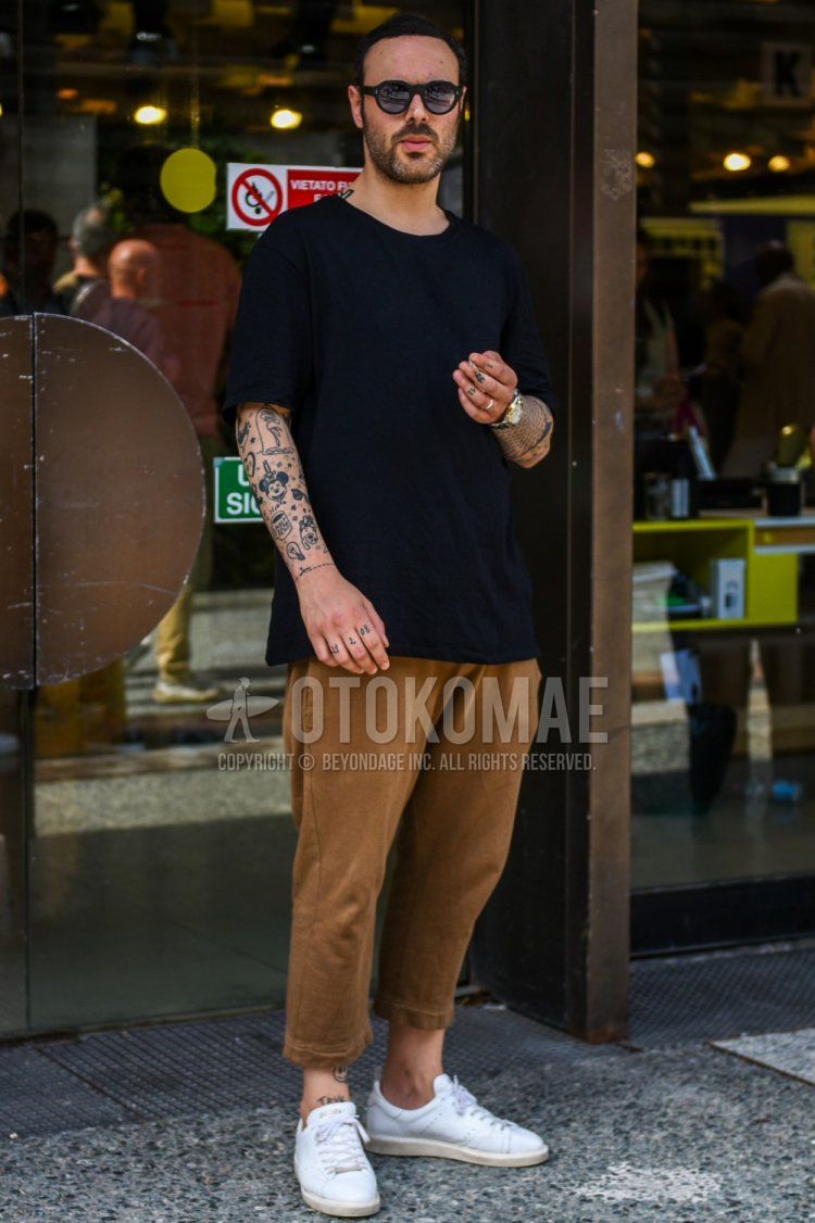 Men's summer coordinate and outfit with plain black sunglasses, plain black t-shirt, plain brown cotton pants, and white low-cut sneakers.