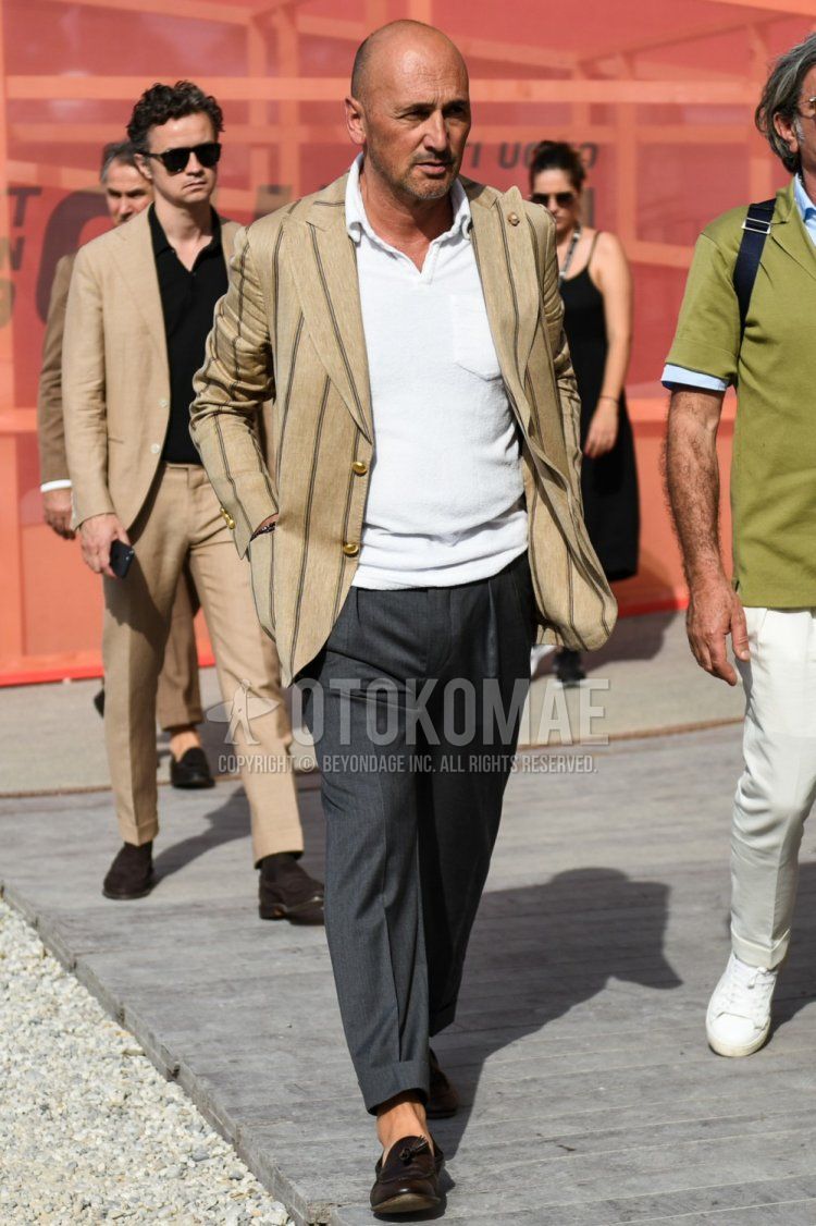Men's spring, summer, and fall coordinate and outfit with beige striped tailored jacket, plain white polo shirt, plain gray slacks, and brown tassel loafer leather shoes.