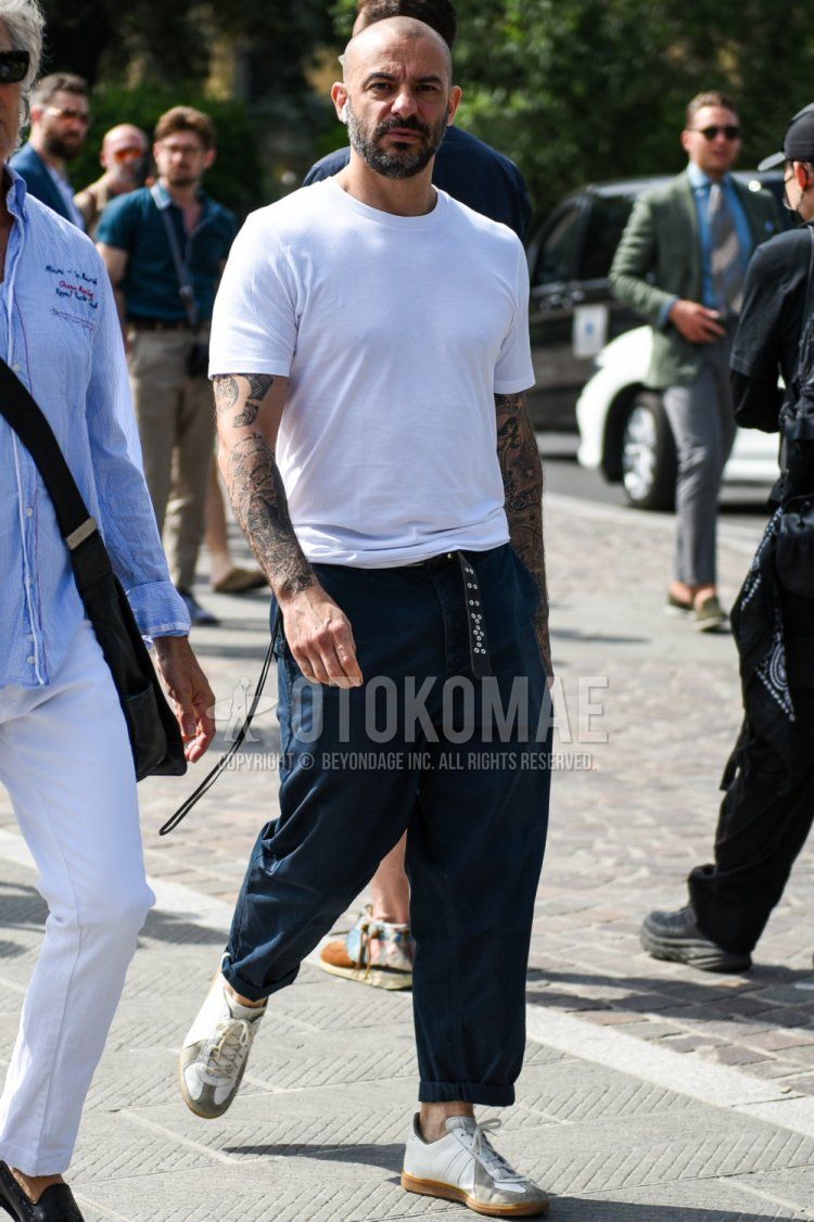 Men's summer coordinate and outfit with plain white T-shirt, plain navy chinos, and white low-cut sneakers.