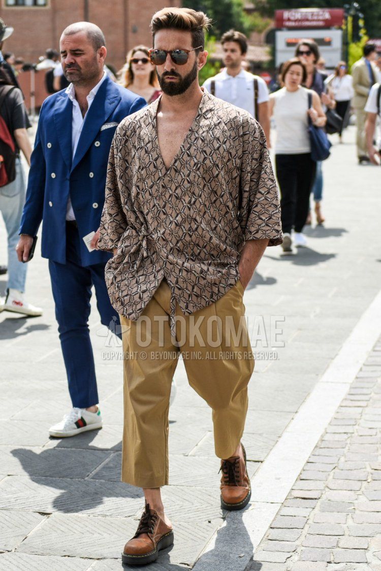 Men's summer coordinate and outfit with brown tortoiseshell sunglasses, beige top/inner shirt, plain beige chinos, plain cropped pants, and Dr. Martens brown plain toe leather shoes.