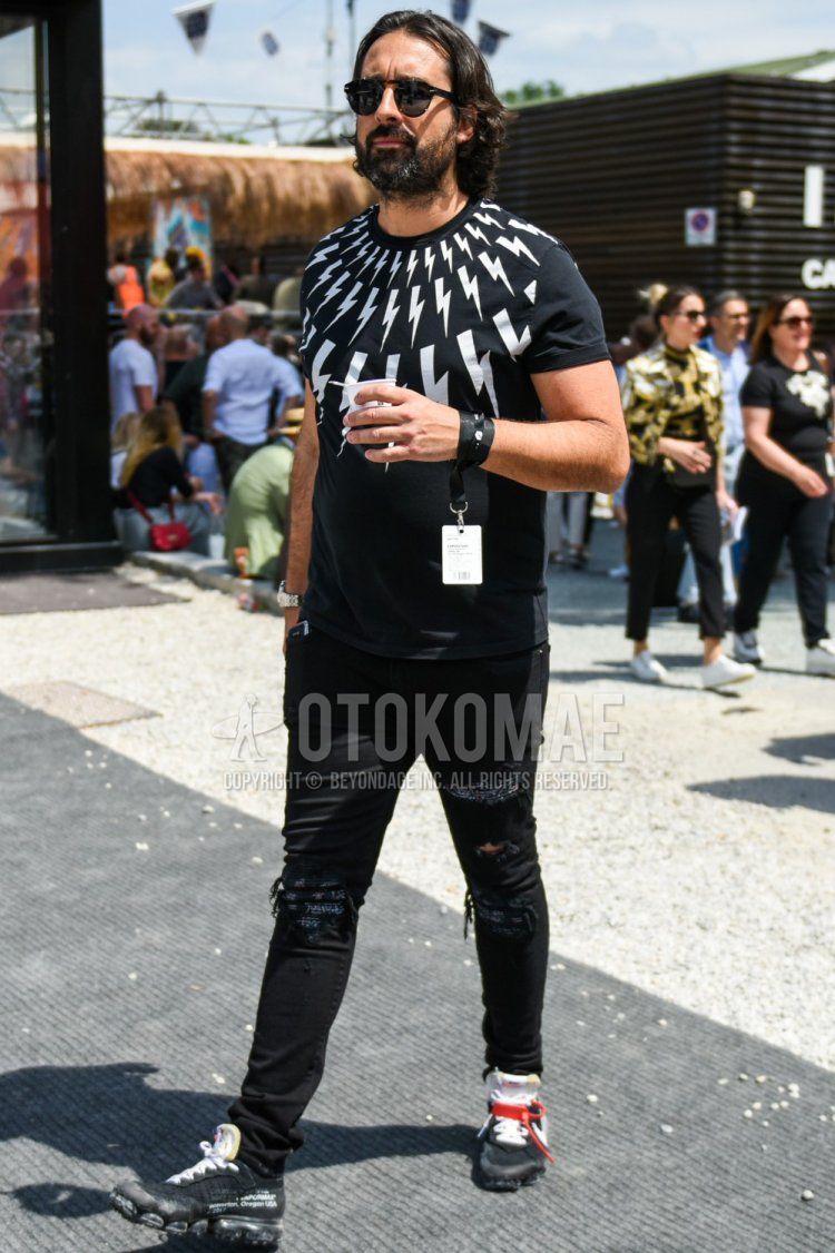 A summer men's coordinate and outfit with plain black sunglasses, a plain black Neil Barrett t-shirt, plain black damaged jeans, and black low-cut sneakers.