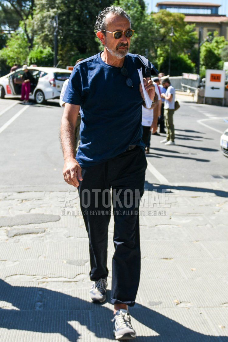Summer men's coordinate and outfit with plain beige sunglasses, plain navy t-shirt, plain navy chinos, and premierta gray low-cut sneakers.