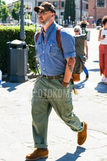 Brown one-pointed baseball cap, teardrop plain black/silver sunglasses, red stole bandana/neckerchief, plain gray shirt, plain brown leather belt, plain olive green cargo pants, plain chinos, multi-colored plain socks, suede brown leather shoes, spring/summer men's coordinate/outfit.