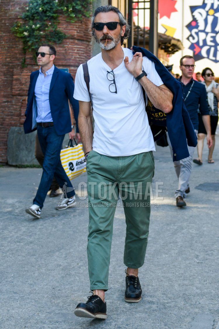 A summer men's coordinate and outfit with plain black sunglasses, plain white t-shirt, plain green cotton pants, and black work boots.