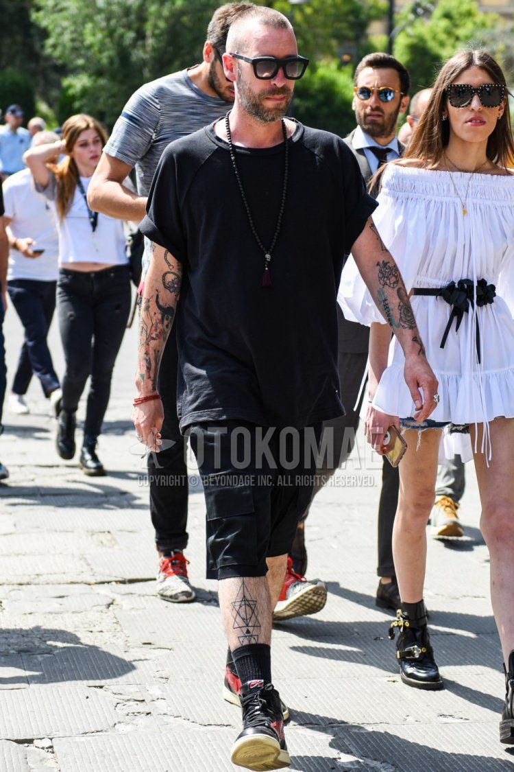 Summer men's coordinate and outfit with Wellington plain black sunglasses, plain black t-shirt, plain black cargo pants, plain black shorts, plain black socks, and Nike black high-cut sneakers.