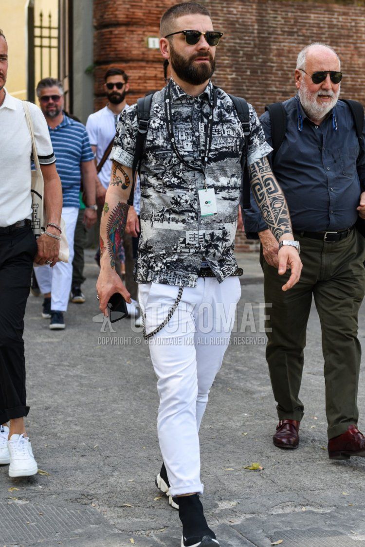 Men's spring, summer, and fall coordinate and outfit with plain black and gold sunglasses, dark gray graphic shirt, plain black leather belt, plain white cotton pants, and black low-cut sneakers.