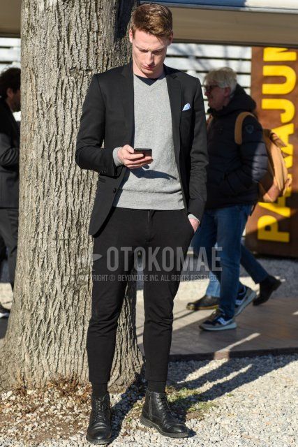 Men's spring and fall coordinate and outfit with plain gray sweater, plain black tailored jacket, plain black cotton pants, plain black cropped pants, plain black socks, and black boots.