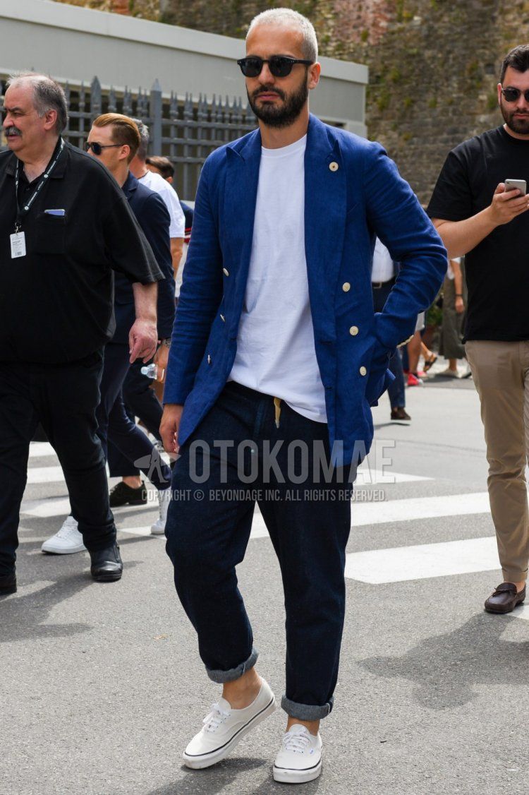 Men's spring/summer/fall coordinate and outfit with plain black sunglasses, plain blue tailored jacket, plain white t-shirt, plain navy denim/jeans, and white low-cut sneakers from Vans.