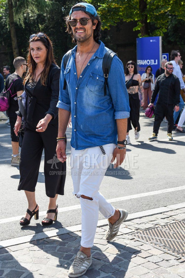 Men's spring, summer, and fall coordinate and outfit with plain blue baseball cap, plain brown sunglasses, plain blue denim/chambray shirt, plain white damaged jeans, and Adidas gray low-cut sneakers.
