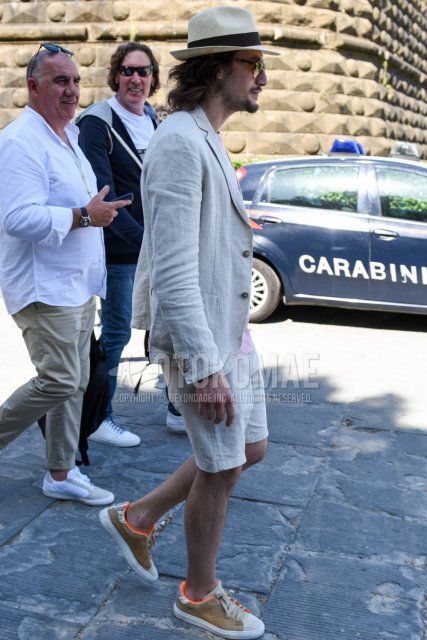 Men's spring, summer, and fall coordinate and outfit with plain beige hat, plain white tailored jacket, plain white shorts, and beige low-cut sneakers.