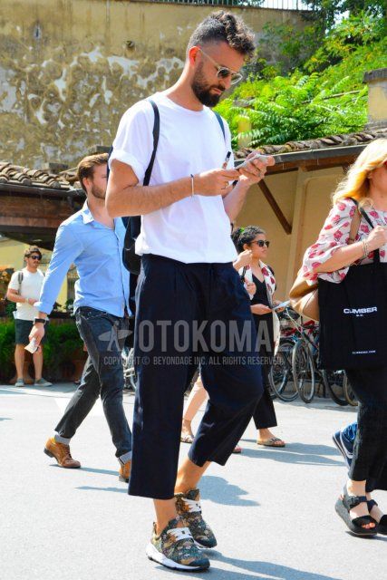 Men's spring/summer coordinate and outfit with clear solid color sunglasses, solid color white t-shirt, dark gray solid color slacks, dark gray solid color pleated pants, and multi-colored low-cut sneakers.