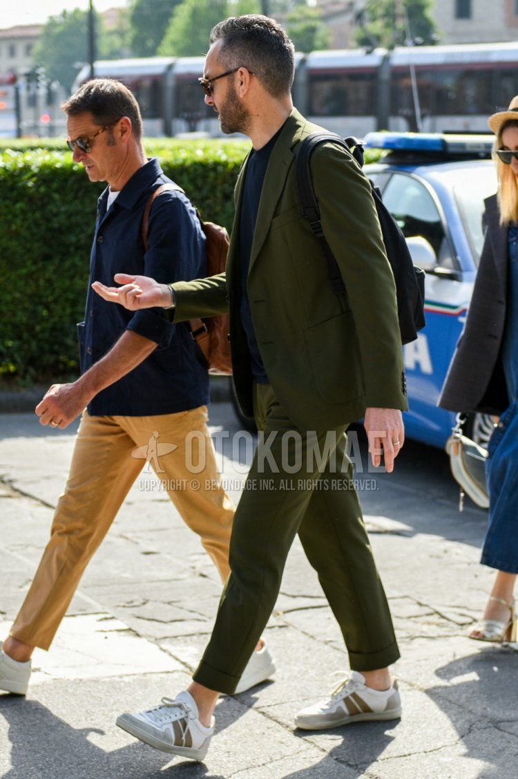 Men's spring and fall coordinate and outfit with olive green solid color T-shirt, white low-cut sneakers, and olive green solid color suit.