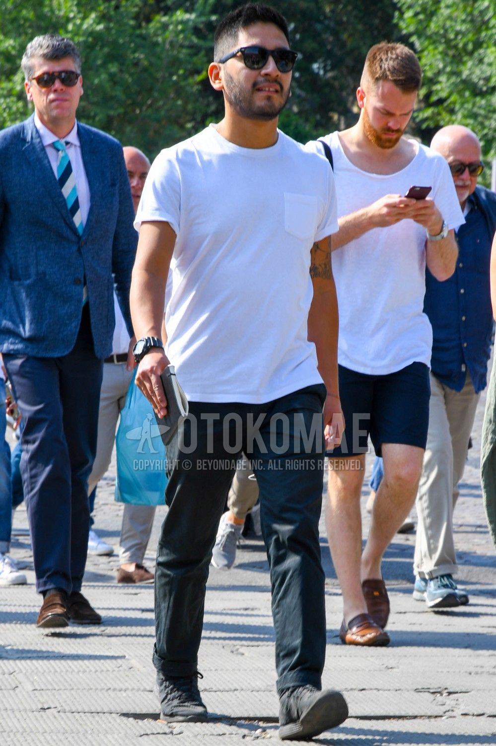 John Legend wearing Navy Polo, Black Chinos, White Leather Low Top Sneakers  | Lookastic