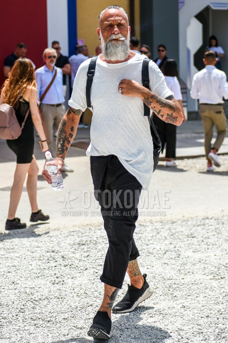 Men's summer coordinate and outfit with plain white T-shirt, plain black easy pants, and black low-cut sneakers.