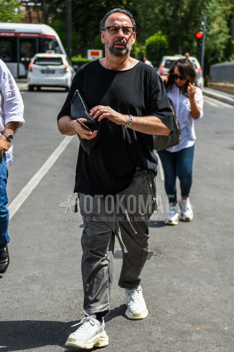 Men's summer coordinate and outfit with plain black glasses, plain black t-shirt, plain gray wide pants, plain gray easy pants, plain black socks, Balenciaga white low-cut sneakers, and plain black clutch/second bag/drawstring bag.
