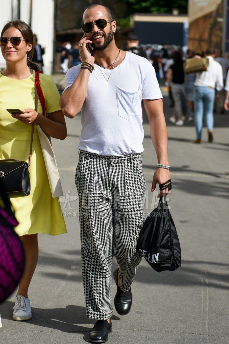 A summer men's coordinate and outfit with plain sunglasses, plain white t-shirt, white and black bottom slacks, bottom pleated pants, and black loafer leather shoes.