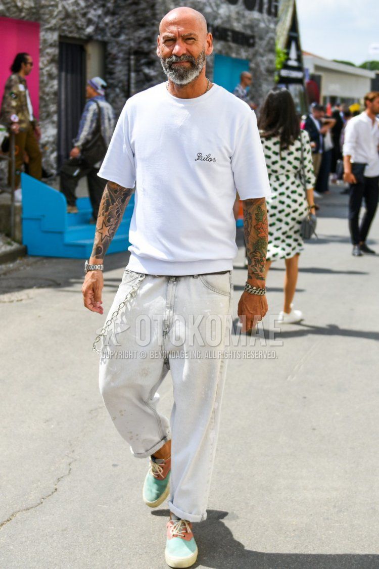 Summer men's coordinate and outfit with white one-pointed T-shirt, plain gray denim/jeans, and green/orange low-cut sneakers.