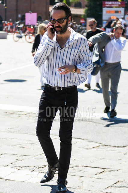 Men's spring/summer coordinate/outfit with plain black Tom Ford sunglasses, white striped shirt, plain black leather belt, plain black denim/jeans, and black boots.