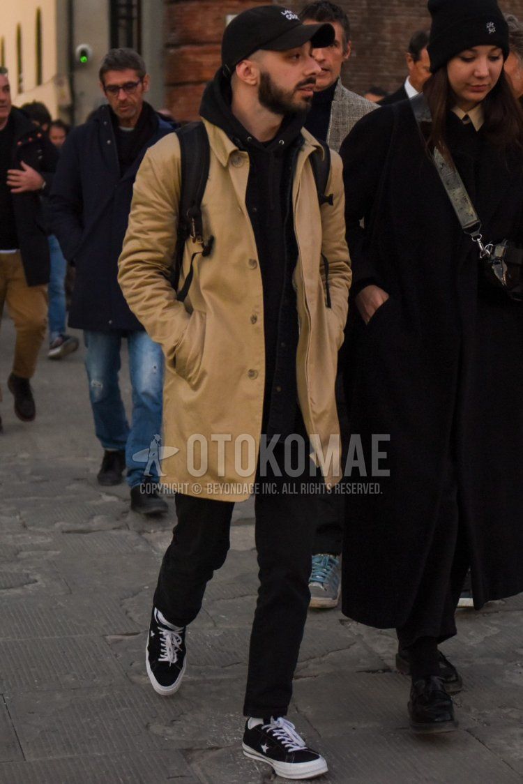 Men's fall/winter coordinate and outfit with plain black baseball cap, plain beige stainless steel collar coat, plain black hoodie, plain black slacks, plain white socks, and Converse One Star black low-cut sneakers.