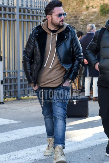 Men's fall/winter coordinate and outfit with plain silver sunglasses, plain black rider's jacket, plain beige hoodie, plain blue denim/jeans, and beige high-cut sneakers.