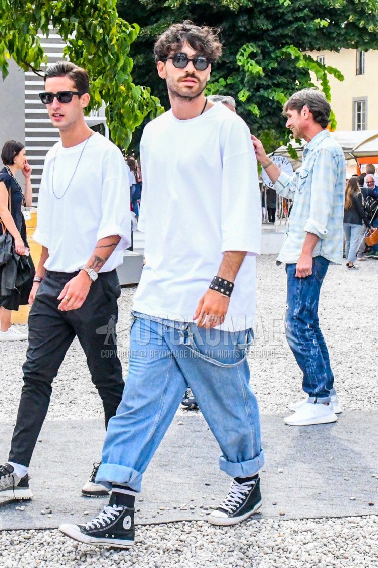 Men's spring and summer coordinate and outfit with plain black sunglasses, overalls plain light blue jumpsuit, plain white t-shirt, plain black socks, and Converse All Star black high-cut sneakers.