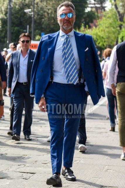 Men's spring, summer, and fall coordination and outfit with plain blue sunglasses, light blue and white striped shirt, black monk shoes leather shoes, plain blue suit, and white and light blue regimental tie.