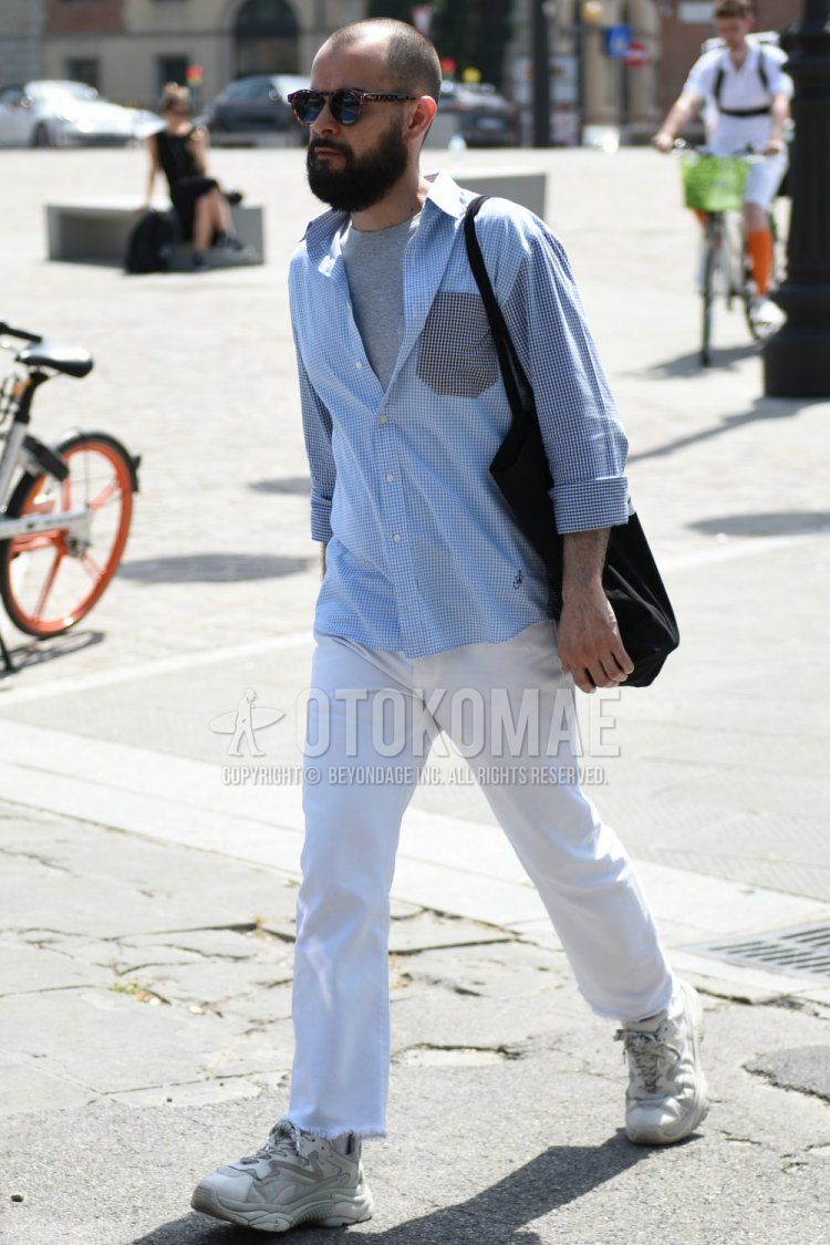 Men's spring and fall coordinate and outfit with brown tortoiseshell sunglasses, plain gray t-shirt, light blue checked shirt, plain white cotton pants, and gray low-cut sneakers.