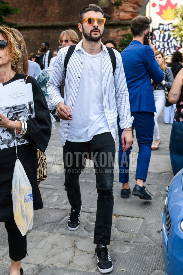 Men's spring/autumn coordinate and outfit with plain orange sunglasses, plain white t-shirt, plain white shirt, plain black denim/jeans, and black low-cut Adidas sneakers.