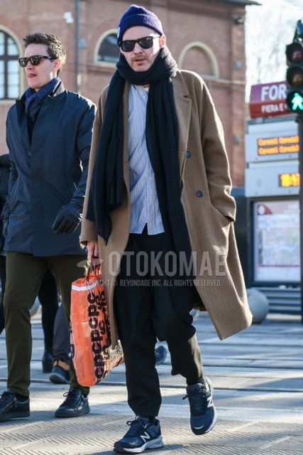 Solid blue knit cap, solid black Wellington sunglasses, solid dark gray scarf/stall, solid beige chester coat, light blue striped shirt, solid dark gray slacks, solid black socks, navy low-cut New Balance sneakers. Men's fall/winter outfits/coordinates.