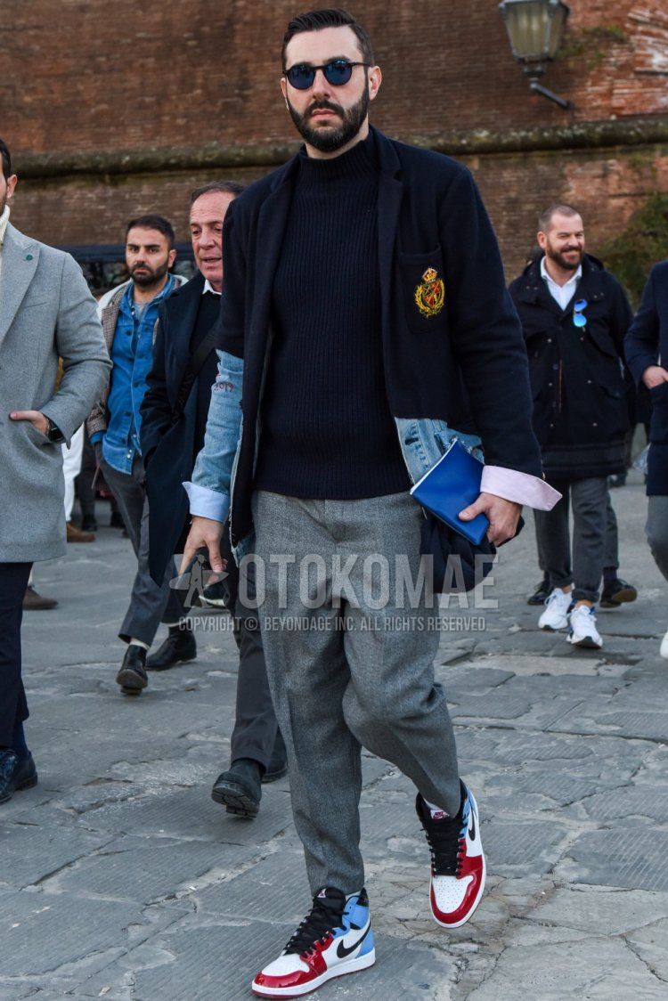 Boston plain black sunglasses, Greg Lauren plain navy tailored jacket, plain navy sweater, plain gray slacks, plain gray cropped pants, Nike Air Jordan 1 white, red, and light blue high-cut sneakers for men in fall and winter. Outfit.